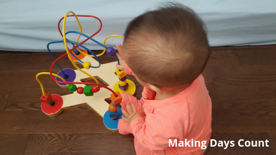 Baby K playing with beads set